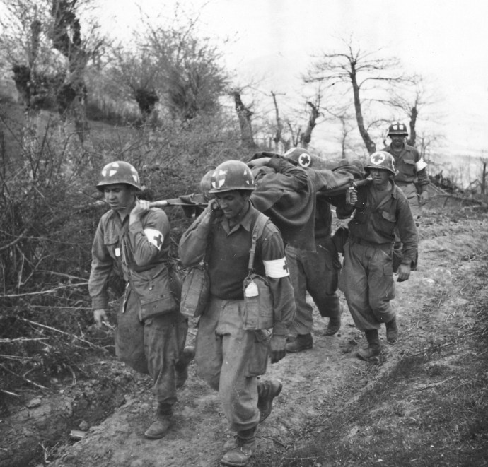 Medics of G Company, 87th Mountain Infantry, 10th Mountain Division, carry a wounded GI to an aide station during the fighting around Bologna, Italy on May 1, 1945.